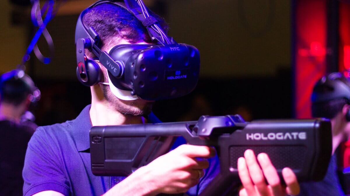 Man in VR with game riffle playing video game